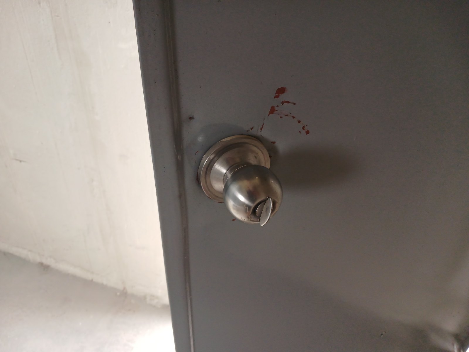 구로구 온수동 출장 — 짙은 회색 철문에 달린 은색 둥근 손잡이와 그 위쪽 붉은 얼룩